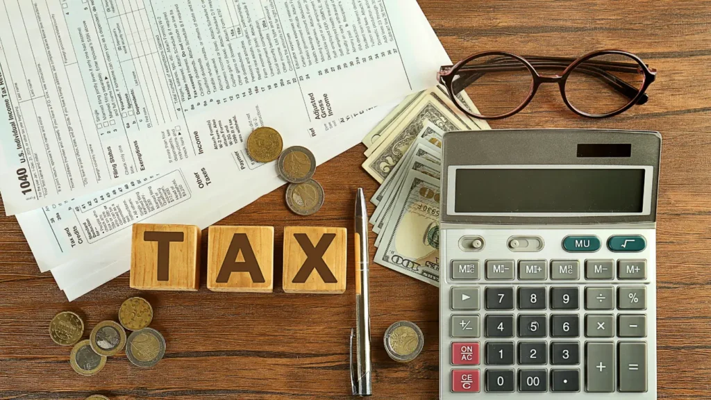 Form 1040, cash, coins, and a calculator illustrating U.S. income tax calculation and tax planning.